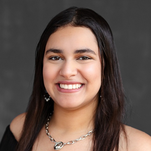 Salma Ahmed, a young Master's student with straight black hair and a large smile.