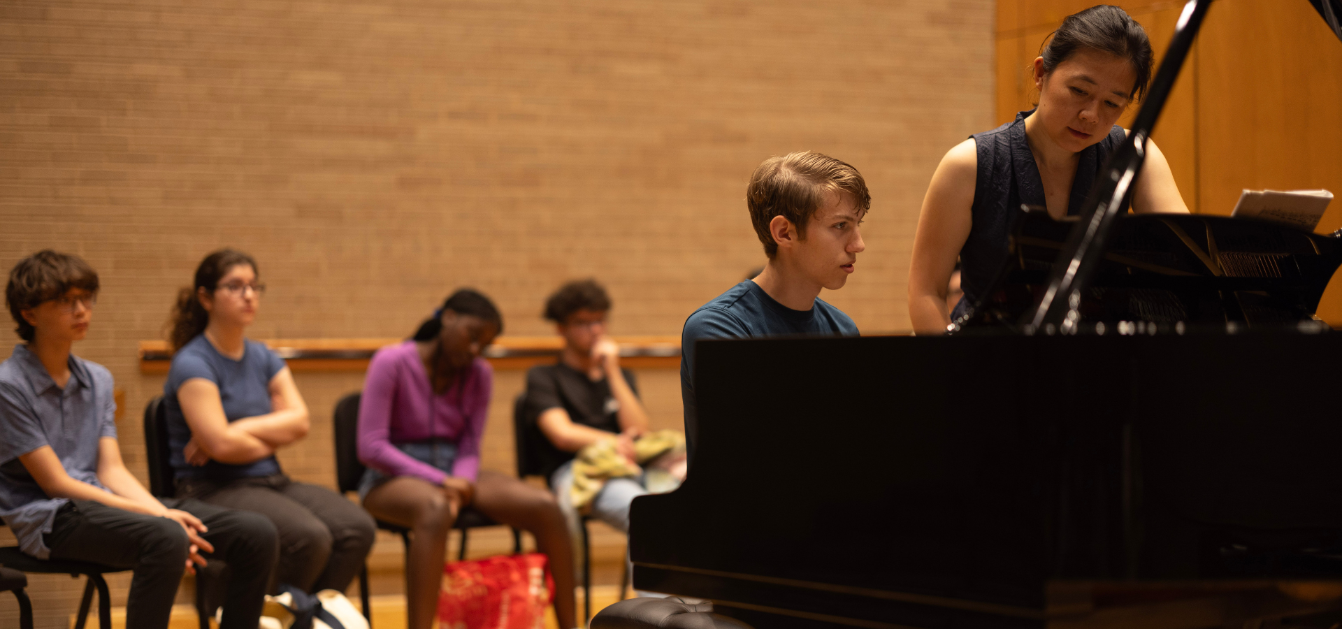 a group of high school keyboard players watching a masterclass