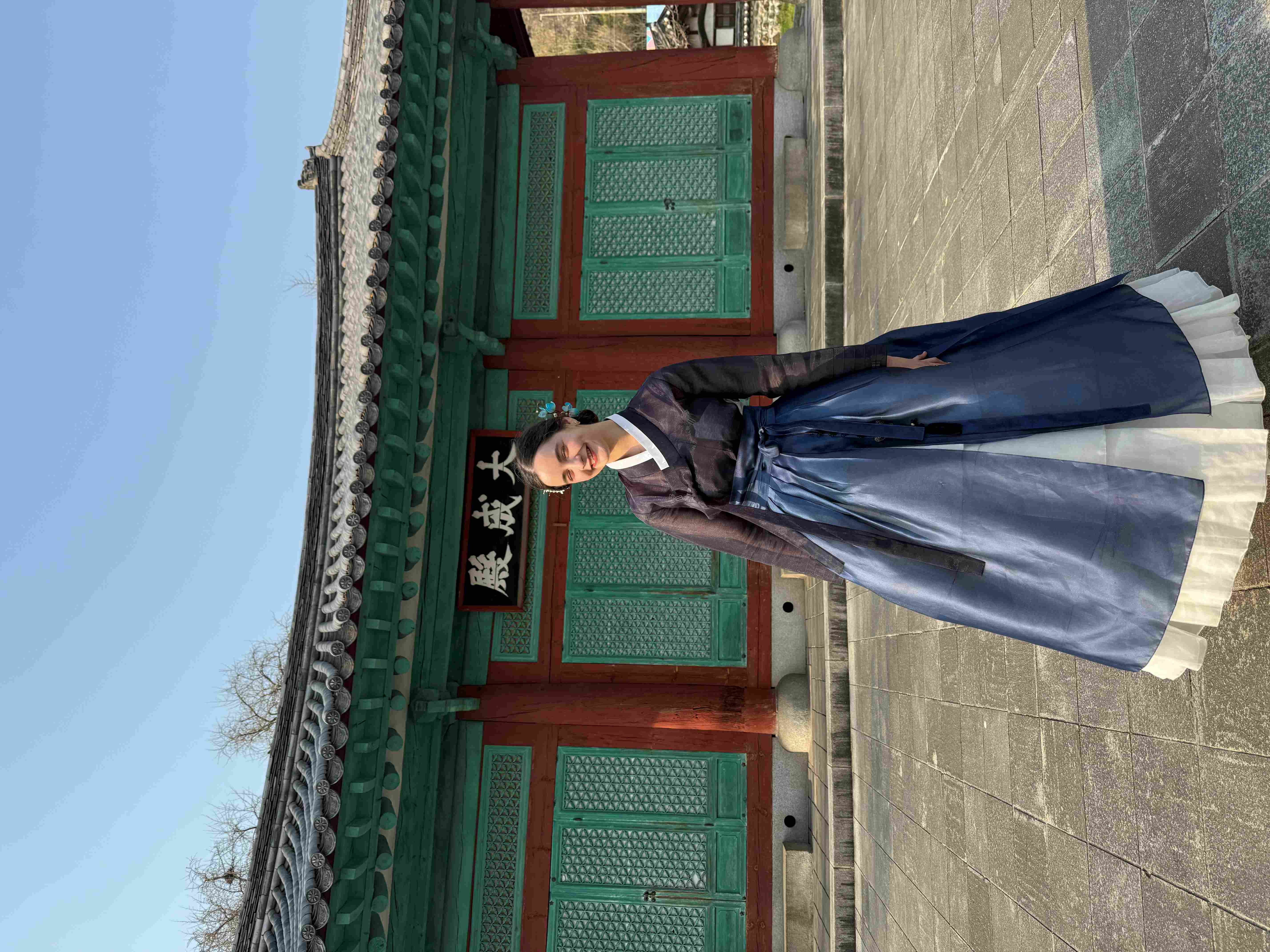 Hannah standing in front of a Korean temple, wearing traditional Korean clothes. 