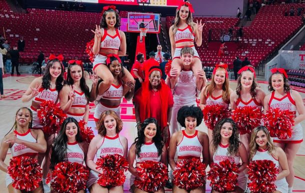 Image of Jackson Lee with UH cheerleaders on basketball court. 