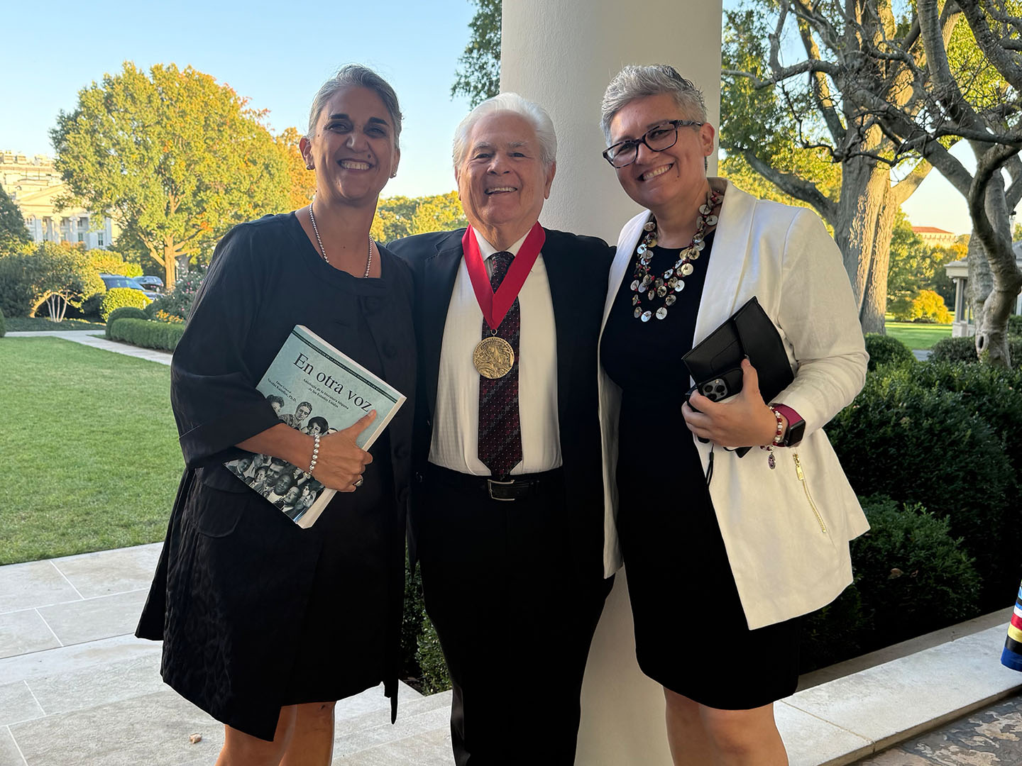 Gabriela Baeza Ventura, Nicolás Kanellos and Carolina Villarroel stand outside the White House.