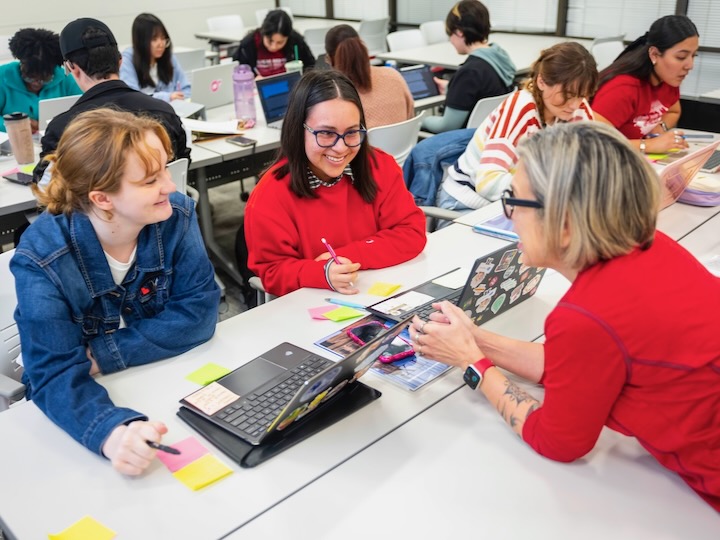 Applied behavior analysis students sit at a desk in class