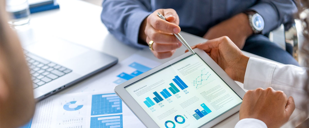 Three people reviewing data on a tablet.