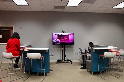 Students sit in an open concept computer lab.